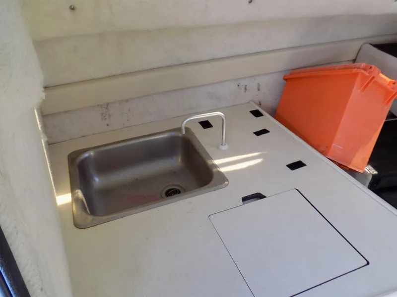 Slide: The Image of 2001 Bayliner 2252 Ciera Classic boat interior with sink and orange storage container. - 5