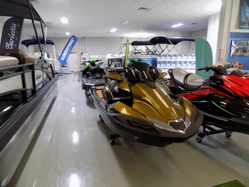 Slide: The Image of 2023 Kawasaki 310 LX jet ski displayed in a showroom with other watercraft. - 1