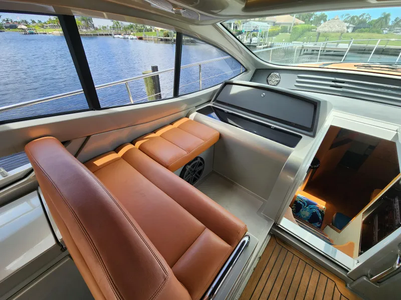 Slide: The Image of Interior of 2006 Pershing Cruiser with brown leather seats and waterfront view. - 14