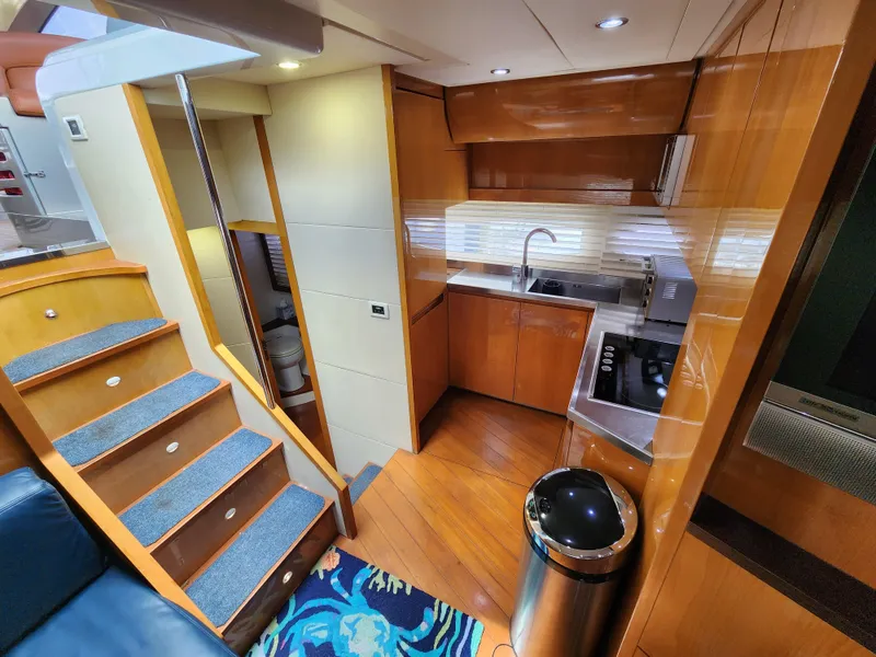 Slide: The Image of 2006 Pershing Cruiser interior with modern kitchen and wooden stairs. - 16