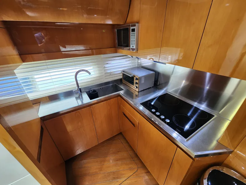 Slide: The Image of 2006 Pershing Cruiser kitchen with modern appliances and wooden cabinetry. - 19