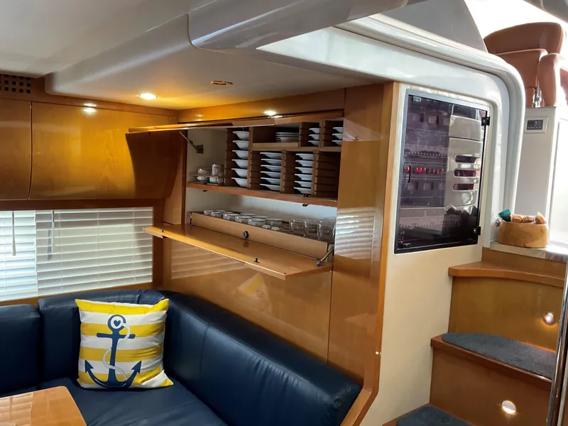 Slide: The Image of Luxurious 2006 Pershing Cruiser interior with wooden cabinetry and navy seating. - 20
