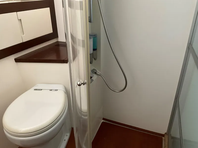 Slide: The Image of Bathroom interior of a 2006 Pershing Cruiser yacht, featuring a toilet and shower. - 21