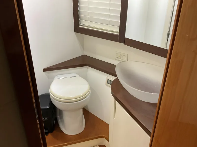 Slide: The Image of Bathroom interior of 2006 Pershing Cruiser with modern fixtures and wooden accents. - 23