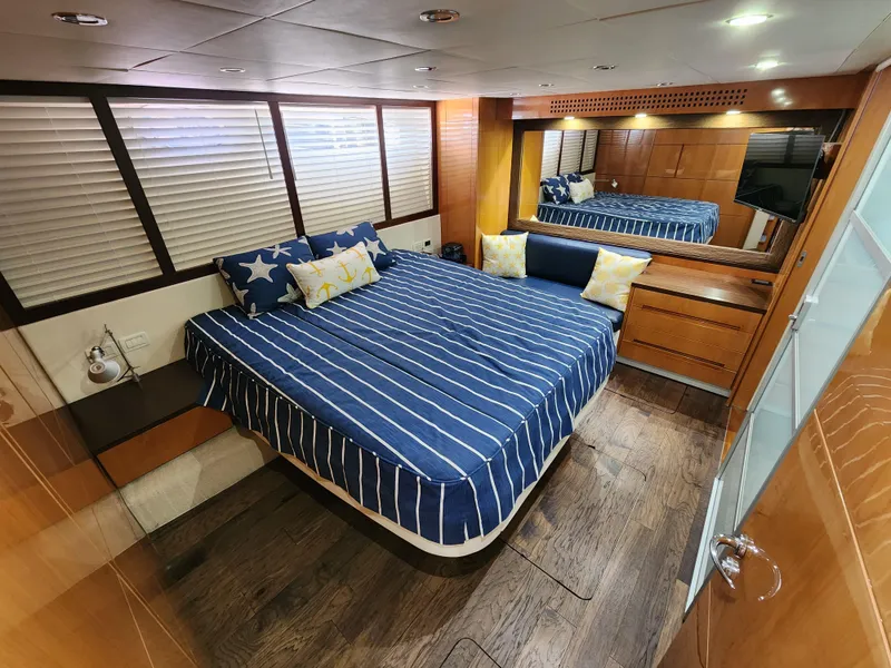 Slide: The Image of Luxurious bedroom interior of a 2006 Pershing Cruiser yacht with striped bedding. - 24