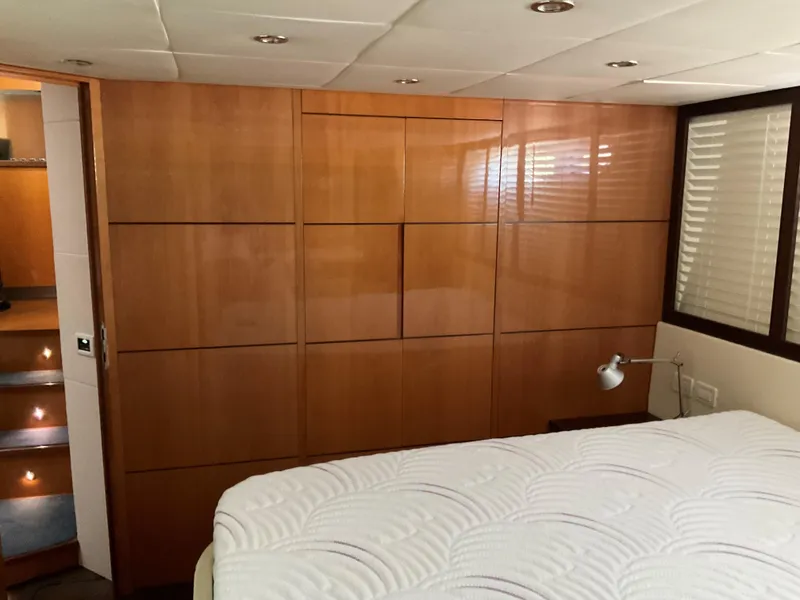 Slide: The Image of Luxurious 2006 Pershing Cruiser bedroom with wood paneling and cozy lighting. - 28