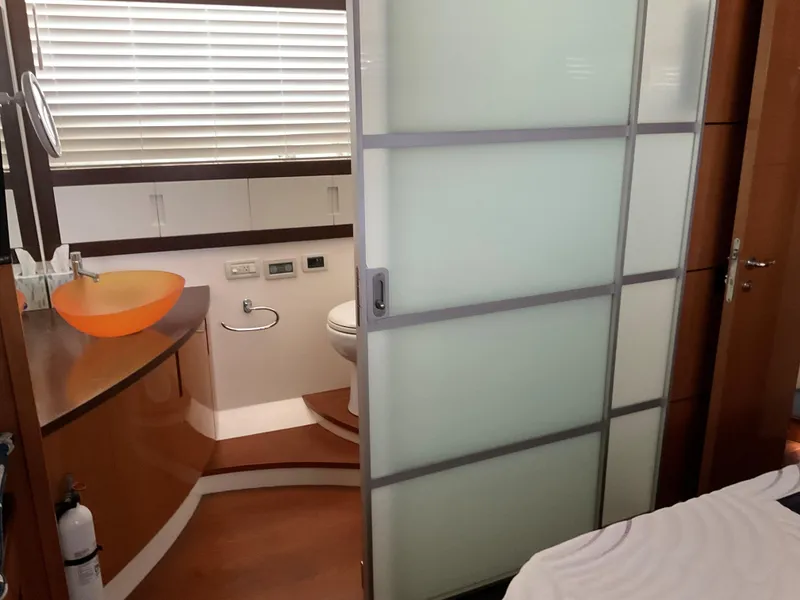 Slide: The Image of 2006 Pershing Cruiser bathroom with modern design, frosted glass door, and orange sink. - 32