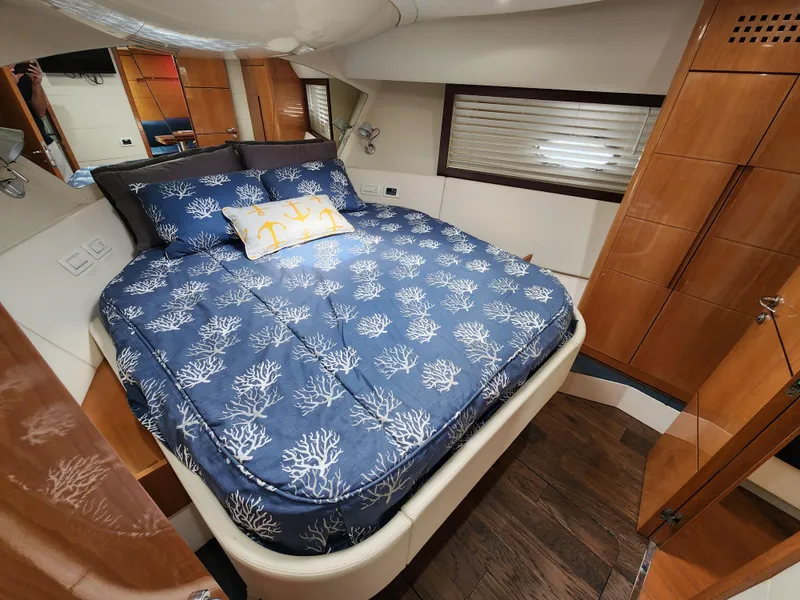 Slide: The Image of Luxurious bedroom in a 2006 Pershing Cruiser with a cozy bed and elegant wood finishes. - 33