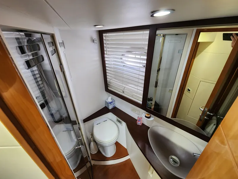 Slide: The Image of 2006 Pershing Cruiser bathroom with modern fixtures, glass shower, and wooden accents. - 35