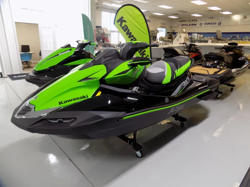 Slide: The Image of 2023 Kawasaki 310 LX-S jet ski in showroom, vibrant green and black design. - 1