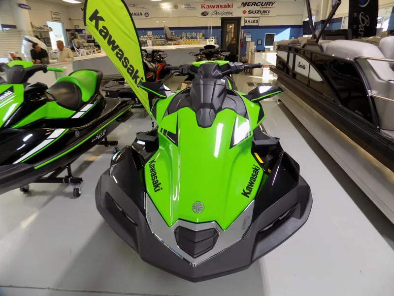 Slide: The Image of 2023 Kawasaki 310 LX-S jet ski in showroom, vibrant green and black design. - 2