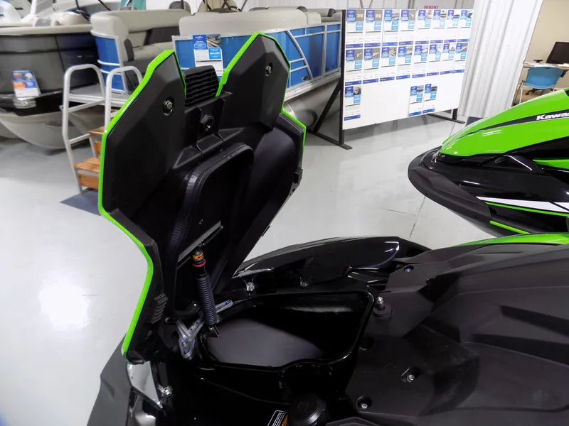 Slide: The Image of 2023 Kawasaki 310 LX-S jet ski with open storage compartment in showroom. - 3