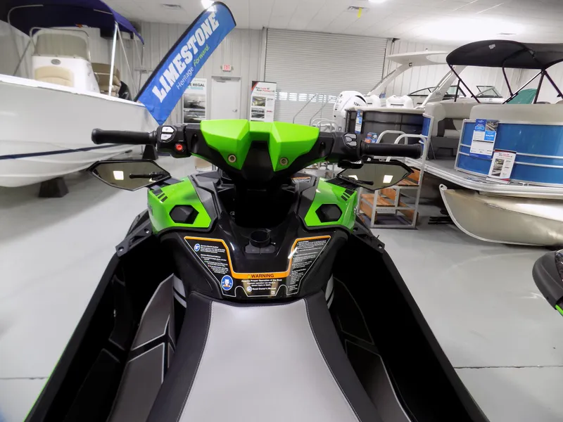 Slide: The Image of 2023 Kawasaki 310 LX-S jet ski in showroom, vibrant green and black design. - 4