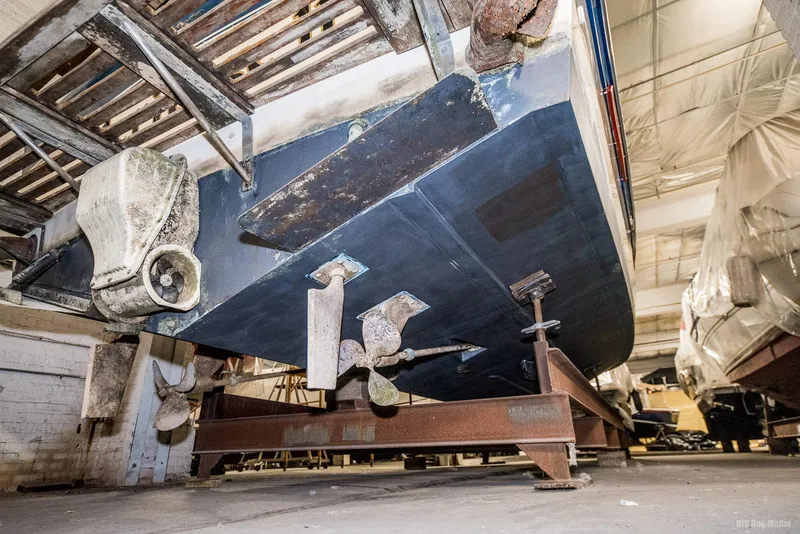 Slide: The Image of 1985 Chris-Craft 336 Mid Cabin boat in storage, showing propellers and hull. - 12