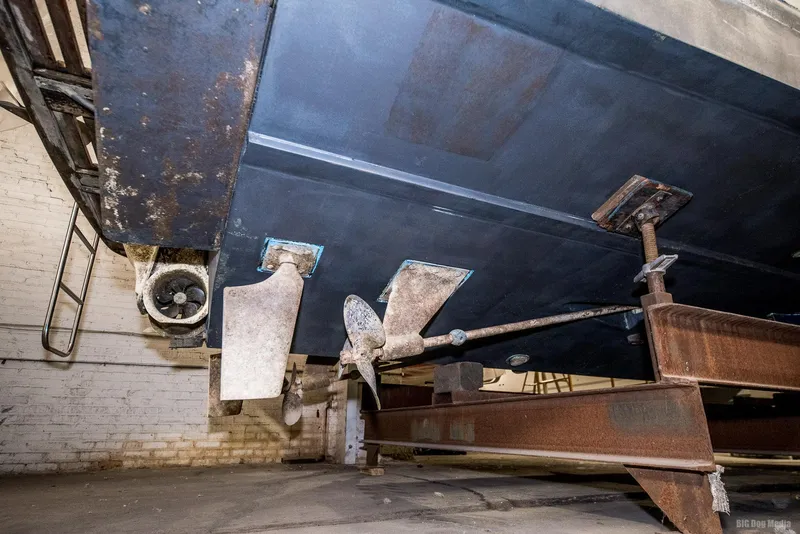 Slide: The Image of 1985 Chris-Craft 336 Mid Cabin boat underside with propeller and rudder in dry dock. - 13