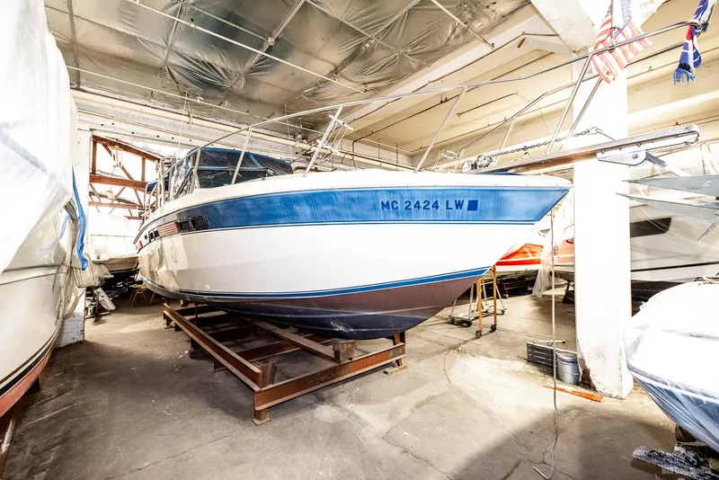 Slide: The Image of 1985 Chris-Craft 336 Mid Cabin boat stored indoors on a stand. - 17