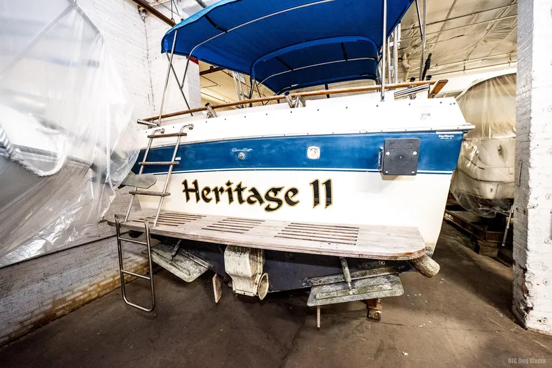 Slide: The Image of 1985 Chris-Craft 336 Mid Cabin boat, named "Heritage II," in storage with blue canopy. - 19