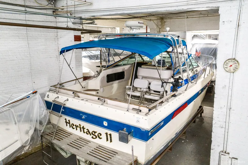 Slide: The Image of 1985 Chris-Craft 336 Mid Cabin boat with blue canopy in storage. - 2