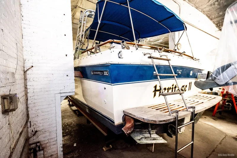 Slide: The Image of 1985 Chris-Craft 336 Mid Cabin boat in storage with blue canopy and ladder. - 20