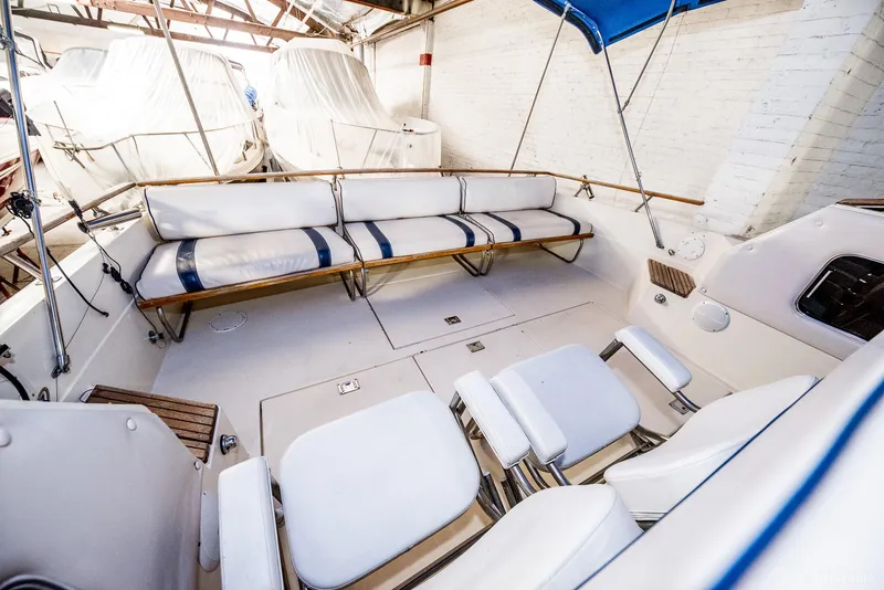 Slide: The Image of 1985 Chris-Craft 336 Mid Cabin boat interior with white seating and blue accents. - 26