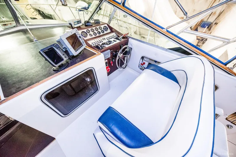 Slide: The Image of 1985 Chris-Craft 336 Mid Cabin helm with navigation equipment and white-blue seating. - 27