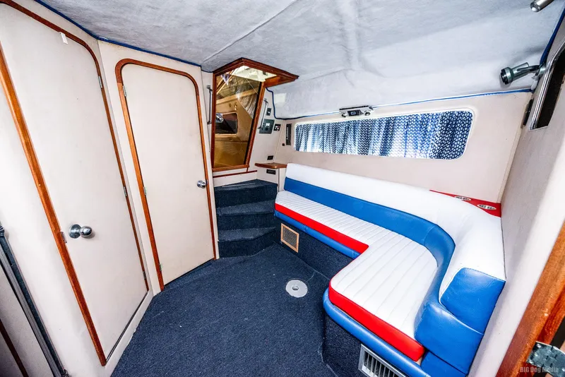 Slide: The Image of 1985 Chris-Craft 336 Mid Cabin interior with colorful seating and carpeted flooring. - 3