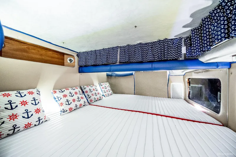 Slide: The Image of 1985 Chris-Craft 336 Mid Cabin interior with nautical-themed bedding and curtains. - 34
