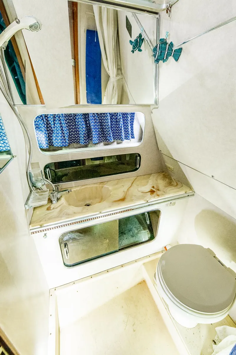 Slide: The Image of 1985 Chris-Craft 336 Mid Cabin bathroom with mirror, sink, and toilet. - 35