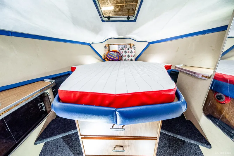 Slide: The Image of 1985 Chris-Craft 336 Mid Cabin interior with bed, storage, and nautical decor. - 37