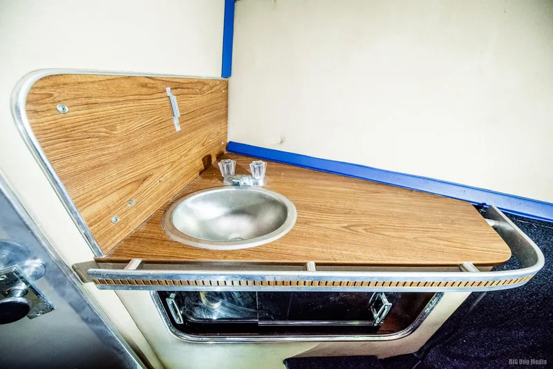 Slide: The Image of 1985 Chris-Craft 336 Mid Cabin sink area with wood finish and metal accents. - 41