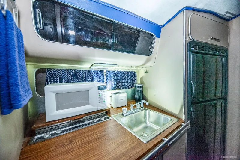 Slide: The Image of 1985 Chris-Craft 336 Mid Cabin kitchen with microwave, sink, and storage. - 42