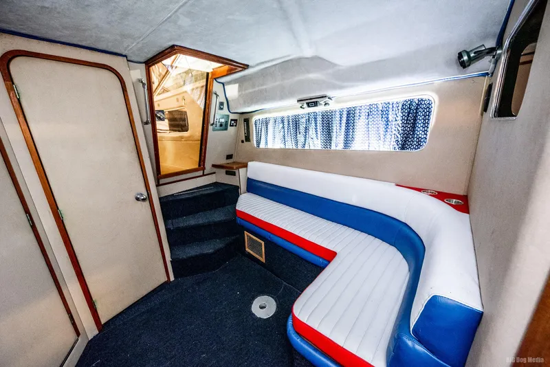 Slide: The Image of 1985 Chris-Craft 336 Mid Cabin interior with blue, red, and white seating. - 43