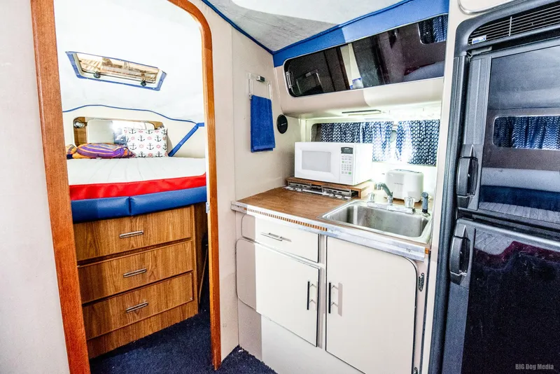 Slide: The Image of 1985 Chris-Craft 336 Mid Cabin interior with kitchenette and cozy sleeping area. - 44