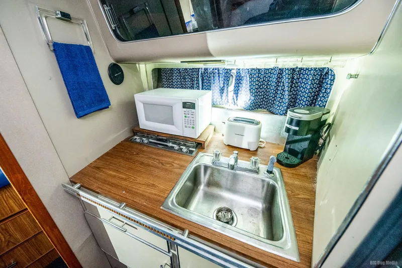 Slide: The Image of 1985 Chris-Craft 336 Mid Cabin kitchen with sink, microwave, toaster, and coffee maker. - 45