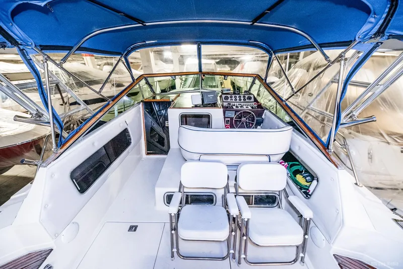 Slide: The Image of 1985 Chris-Craft 336 Mid Cabin boat interior with blue canopy and white seating. - 49