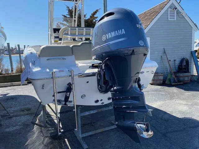 Slide: The Image of 2023 Key West 189 FS boat with Yamaha outboard motor, docked near a waterfront. - 2