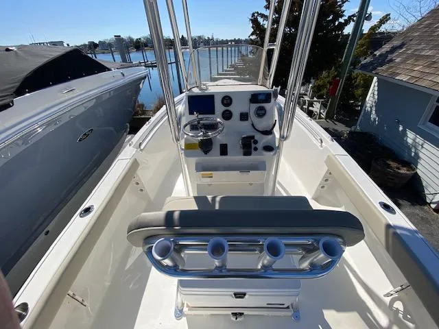 Slide: The Image of 2023 Key West 189 FS boat interior with steering console and rod holders, docked by the water. - 4