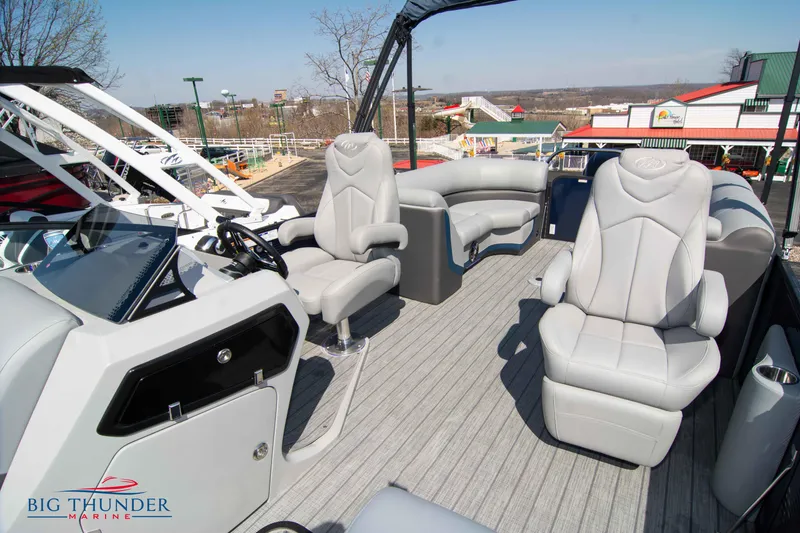 Slide: The Image of 2022 Manitou 25 OASIS RF SHP pontoon boat interior with plush seating and modern dashboard. - 10