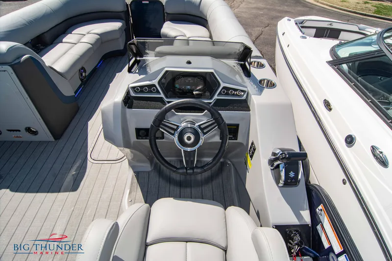 Slide: The Image of 2022 Manitou 25 OASIS RF SHP boat interior with steering wheel and seating. - 11