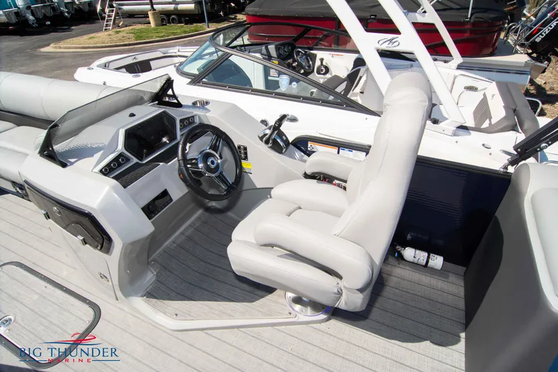 Slide: The Image of 2022 Manitou 25 OASIS RF SHP boat interior with steering wheel and seating. - 20
