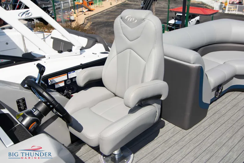 Slide: The Image of 2022 Manitou 25 OASIS RF SHP boat interior with captain's chair and steering wheel. - 21