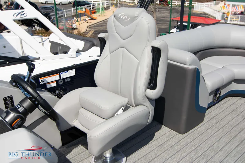 Slide: The Image of 2022 Manitou 25 OASIS RF SHP boat interior with gray captain's chair and dashboard. - 22