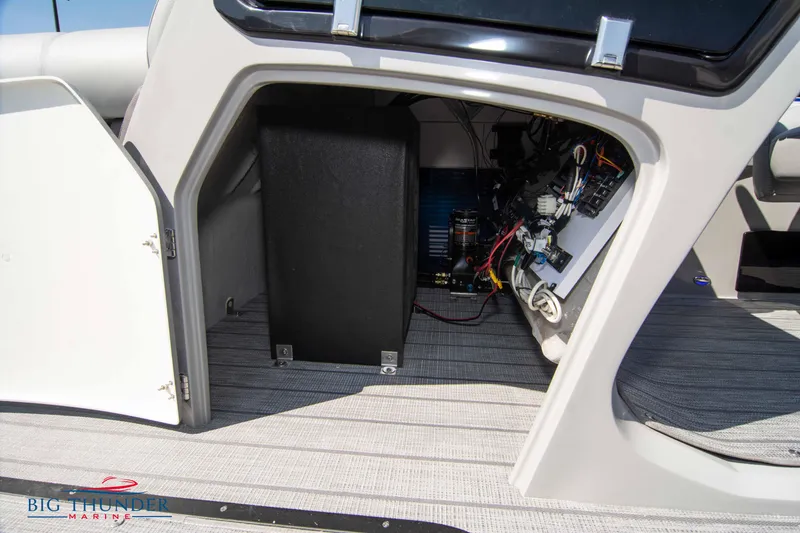 Slide: The Image of 2022 Manitou 25 OASIS RF SHP boat interior storage compartment with visible wiring. - 38