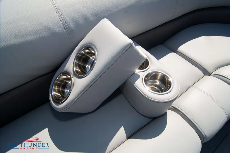Slide: The Image of 2022 Manitou 25 OASIS RF SHP boat interior with cup holders and plush seating. - 42