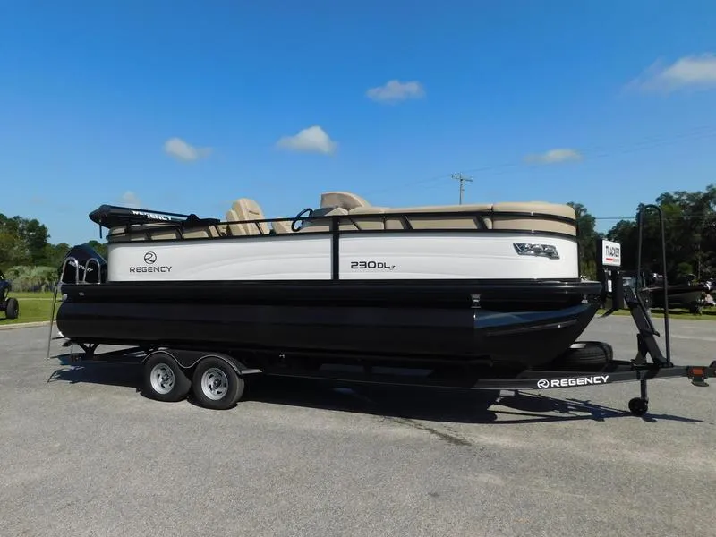 Slide: The Image of 2023 Regency 230 DL3 pontoon boat on trailer under clear blue sky. - 1