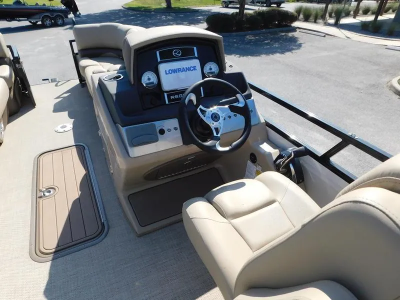 Slide: The Image of 2023 Regency 230 DL3 boat cockpit with steering wheel and Lowrance electronics. - 11