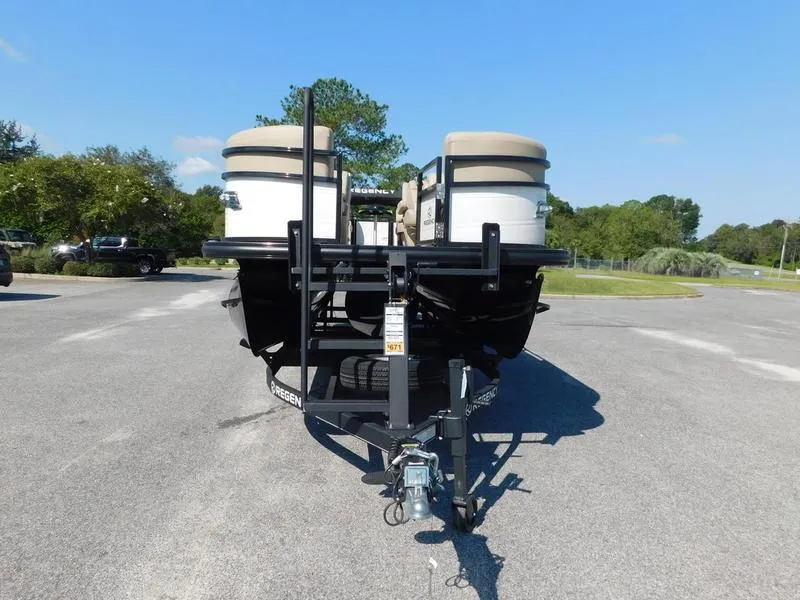Slide: The Image of 2023 Regency 230 DL3 pontoon boat on a trailer in a parking lot. - 2