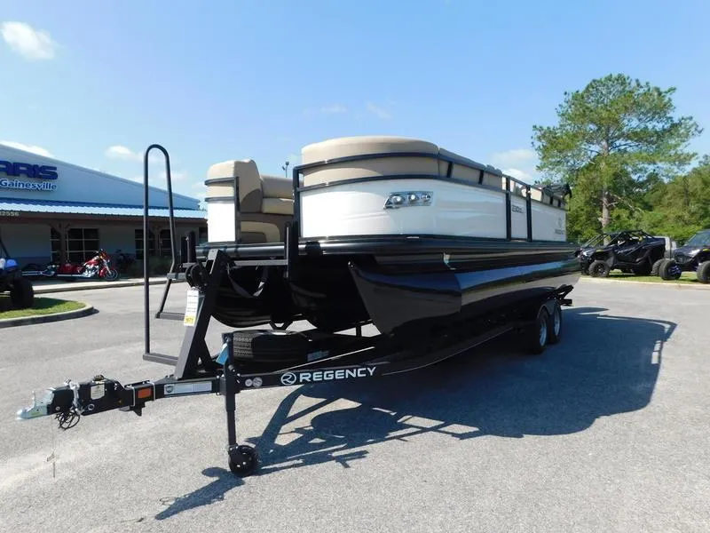 Slide: The Image of 2023 Regency 230 DL3 pontoon boat on a trailer in a parking lot. - 3