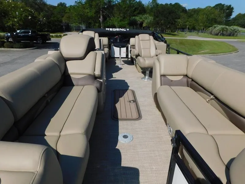 Slide: The Image of 2023 Regency 230 DL3 pontoon boat with beige seating and spacious deck. - 7