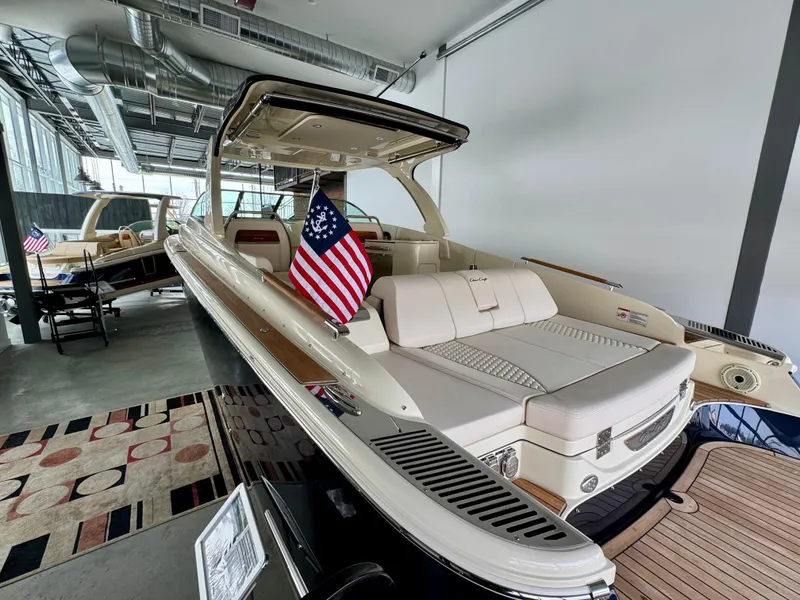 Slide: The Image of 2024 Chris-Craft Launch 35 GT boat displayed indoors with American flag. - 33
